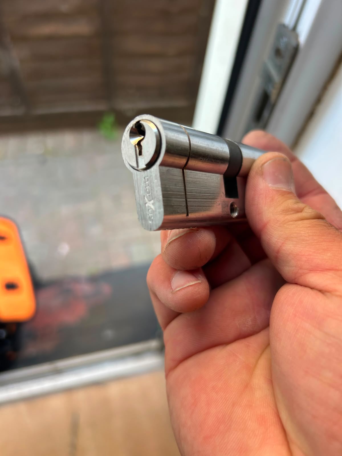 Locksmith holding a euro cylinder lock with key during a call-out