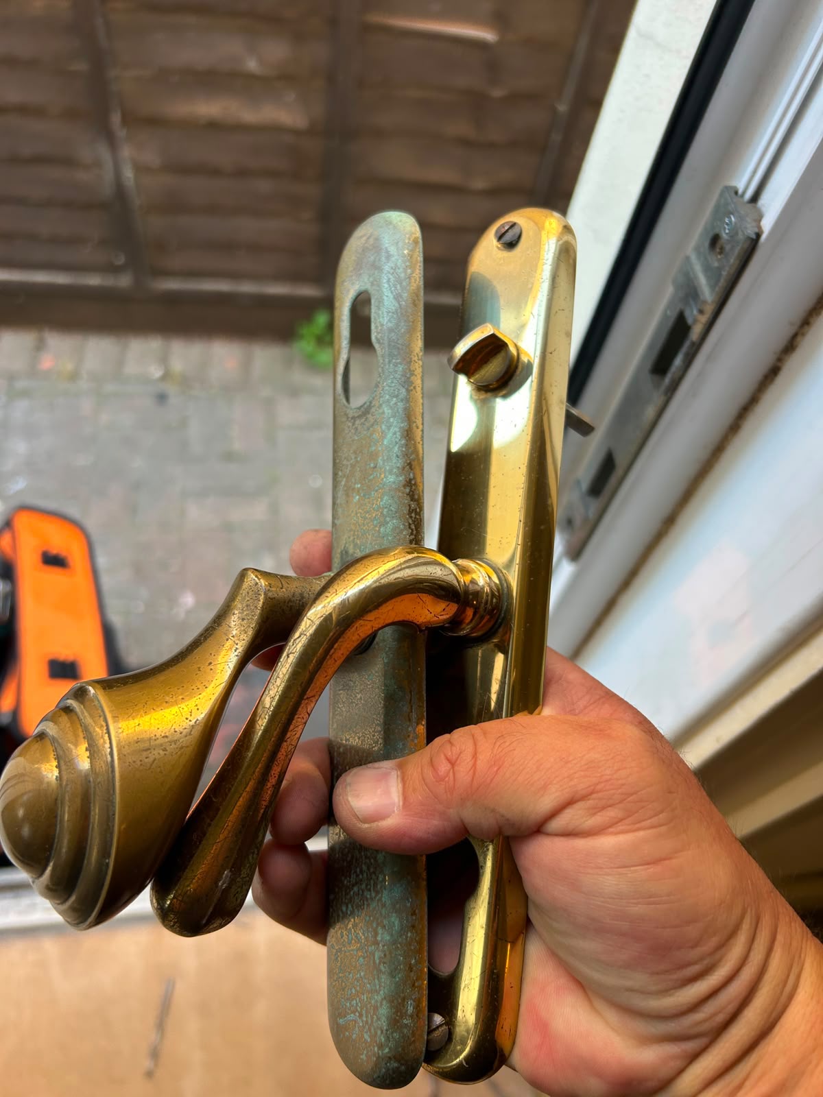 Old worn brass door handle backplates removed from a door
