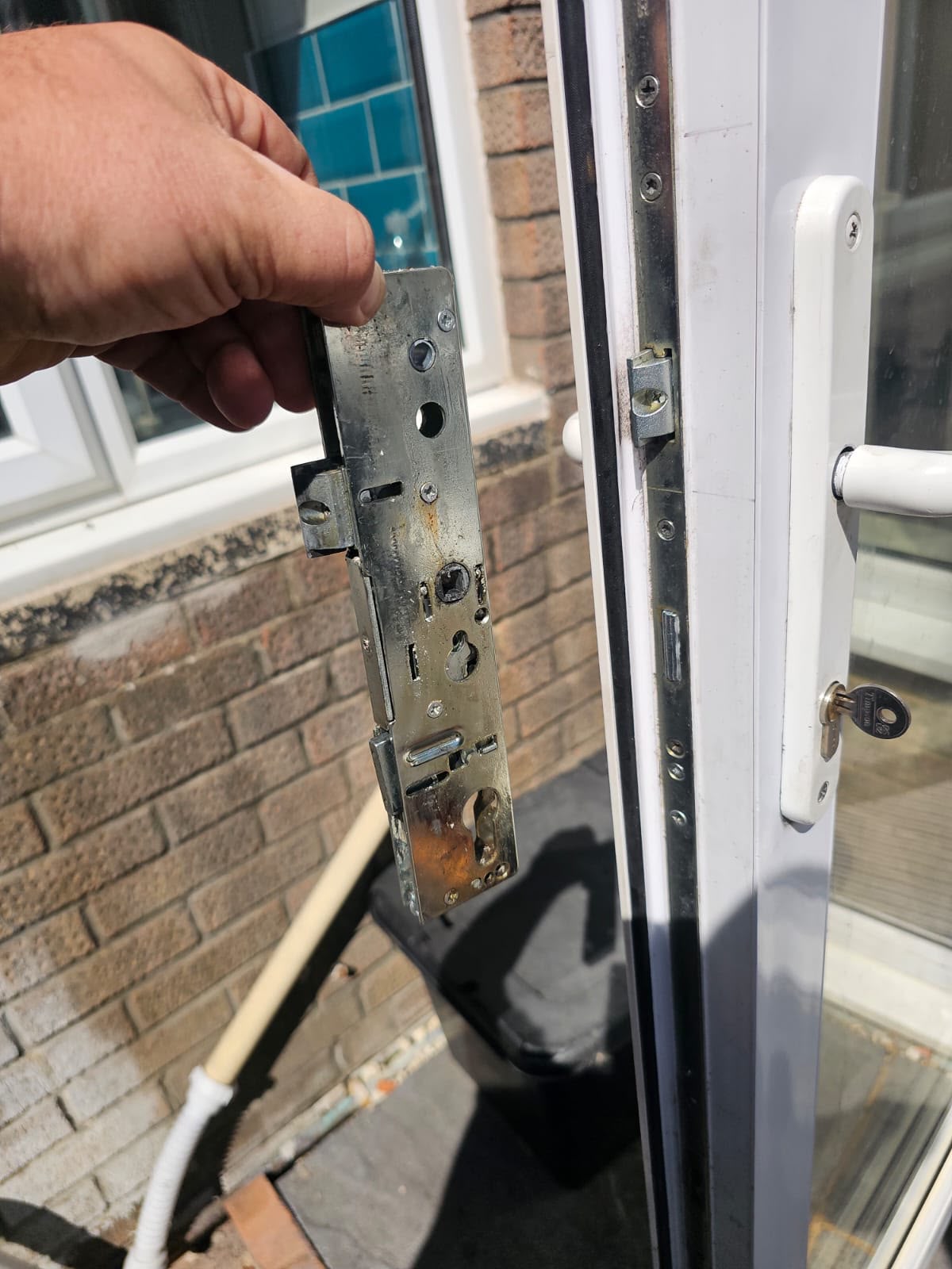 Rusty corroded multi-point lock mechanism held next to a door