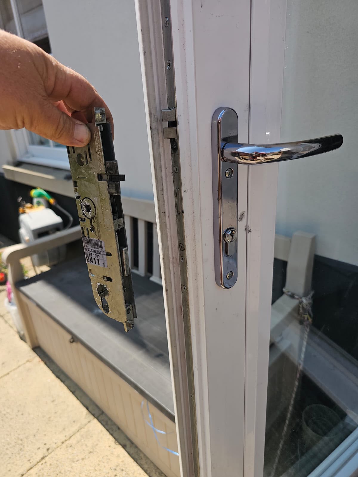 Old multi-point lock mechanism removed next to a uPVC French door