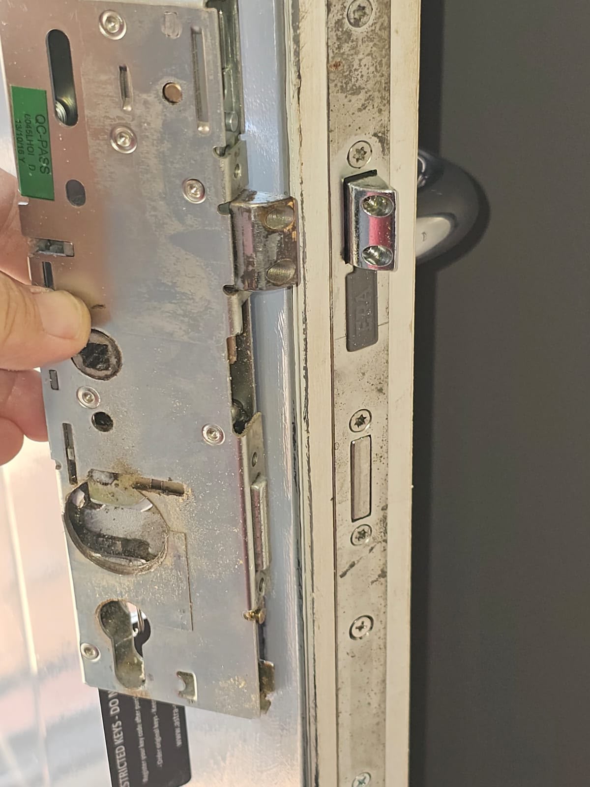 Close-up of a worn, corroded multi-point lock mechanism